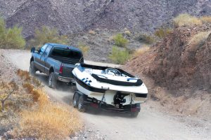 A truck towing a boat up a dirt hill in Australia